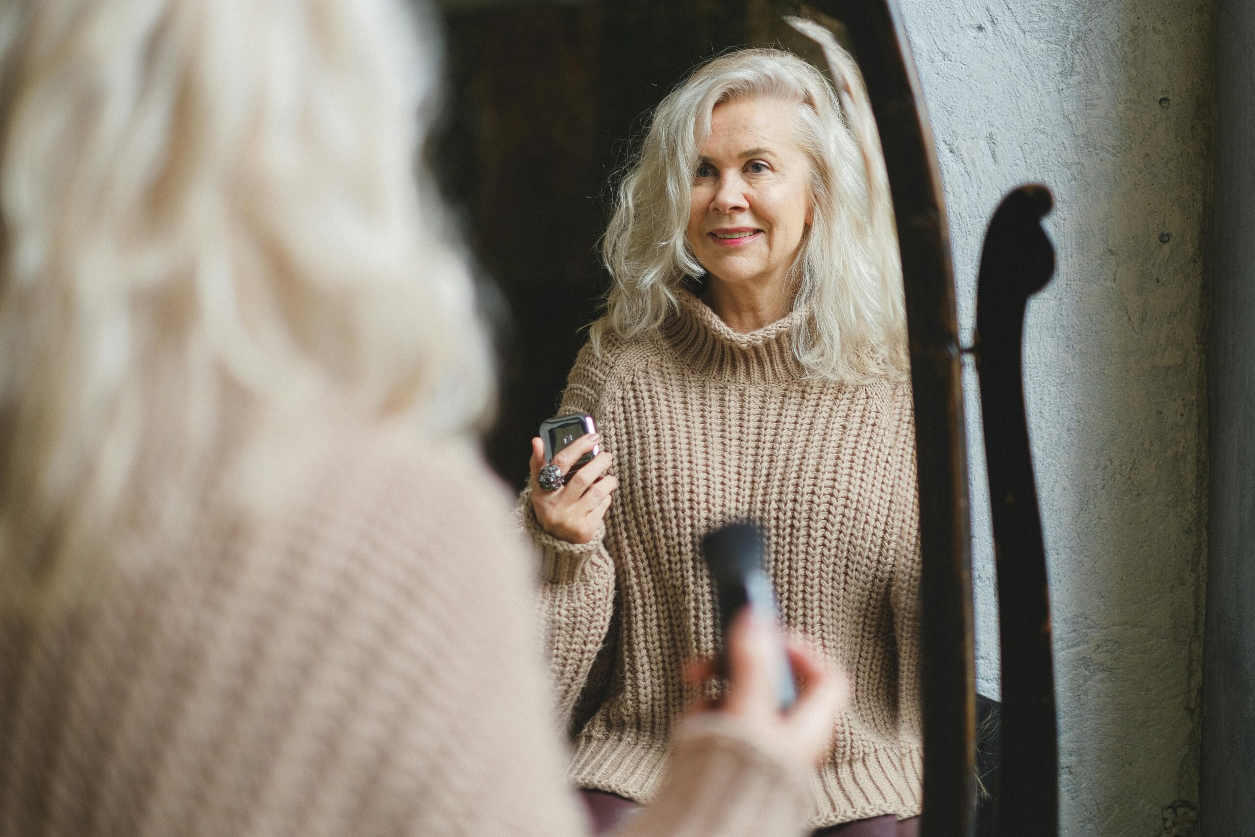 Older woman smiling at her reflection in a mirror - Periodontist Southern Pines & Sanford NC | Van Scoyoc Periodontics & Implants Older woman smiling at her reflection in a mirror